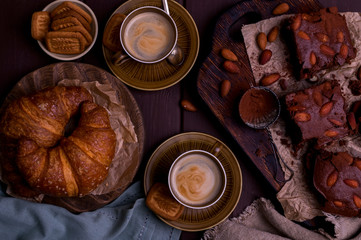 Brownie and croissant for breakfast with aromatic coffee. Traditional american pie and italian espresso. Tasty vintage breakfast. Top view. Free space for text.croissant Top view.