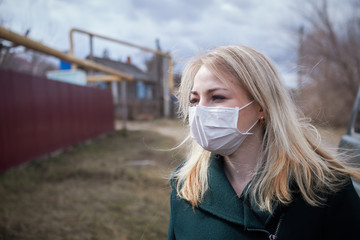 blonde girl in a medical mask on the street