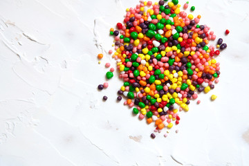 Fototapeta na wymiar Rainbow colored candy sprinkled on a white background