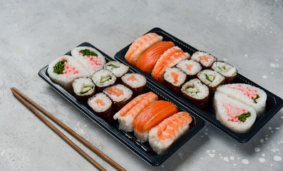 sushi and rolls takeaway food. takeout set rolls and sushi food delivery. set with salmon and shrimp. service food order online during the COVID-19 coronavirus quarantine