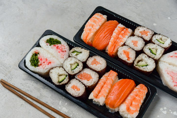 food delivery. set of sushi and rolls with salmon and shrimp. service food order online and home delivery during the COVID-19 coronavirus quarantine . concept layout 2 for the price of 1.