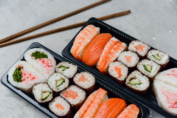 sushi and rolls takeaway food. takeout set rolls and sushi food delivery. set with salmon and shrimp. service food order online during the COVID-19 coronavirus quarantine