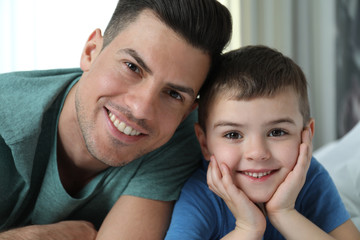 Fototapeta premium Dad and son spending time together at home, closeup. Happy Father's Day