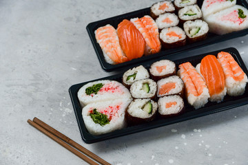 food delivery. set of sushi and rolls with salmon and shrimp. service food order online and home delivery during the COVID-19 coronavirus quarantine . concept layout 2 for the price of 1.