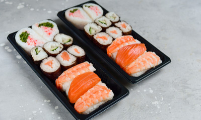 food delivery. set of sushi and rolls with salmon and shrimp. service food order online and home delivery during the COVID-19 coronavirus quarantine . concept layout 2 for the price of 1.
