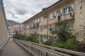 Old archaic house and modern ones on background. Sochi, Russia.