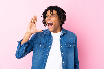 Young African American man with jean shirt over isolated pink background shouting with mouth wide open