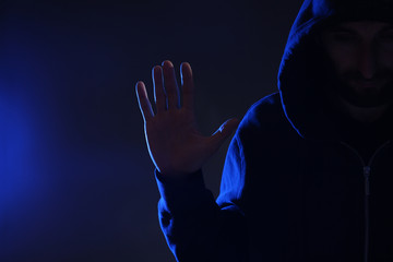 Man in hood on dark background. Cyber crime