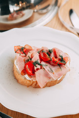 Fresh bread and tomatoes on bread. Bruschetta on a plate with bacon.