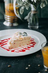  Slice of cake with berries and cream. A piece of Napoleon cake on a white plate.
