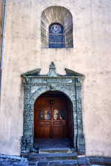 Stone portal and window with a window to the historic church in France.
