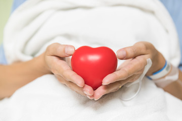 Woman patient hold love heart in hospital eard
