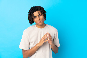Young African American man over isolated blue background scheming something