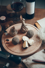 Cheese composition with wine and glass. Dried goat's cheese in balls with pepper.