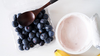 Blueberry yogurt on a white wooden table. Fresh yogurt. Healthy eating concept. High Resolution Product. View from above