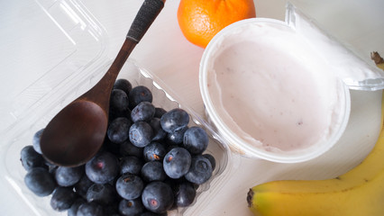 Blueberry yogurt on a white wooden table. Fresh yogurt. Healthy eating concept. High Resolution Product. View from above