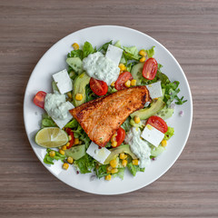 Fresh healty green salad, with tomatoes, lime, feta and salmon