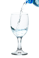 The water from the bottle is poured into a separate glass on a white background. Concept for health