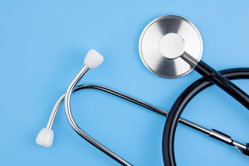 A stethoscope is isolated on a blue background. The concept of medical equipment, cardiology, lung diagnosis, coronavirus, diagnosis of pneumonia. Copy space