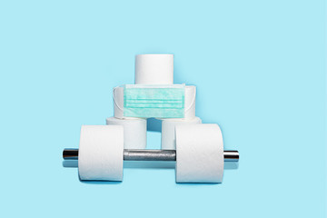 Concept of toilet paper and dumbbell for home quarantine from coronavirus.