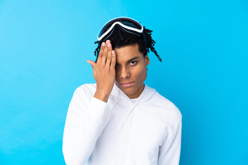 Young African American man with snowboarding glasses covering a eye by hand