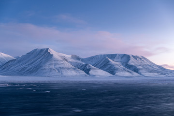 The mountains of Svalbard in the pastel colors of the middle of the day during the polar night in Arctic.