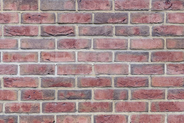 Fragment of the wall of an old building made of baked brick in natural light. Close-up. Texture. Background.