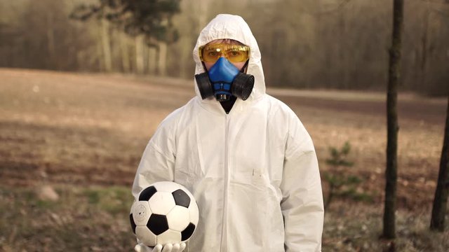 A man in a protective suit with a soccer ball