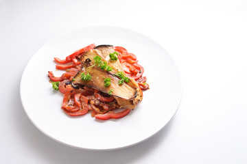 King oyster mushrooms and red bell pepper on a white plate, healthy vegetable meal for low carb diet and vegetarians, white background with copy space, selected focus, narrow depth of field