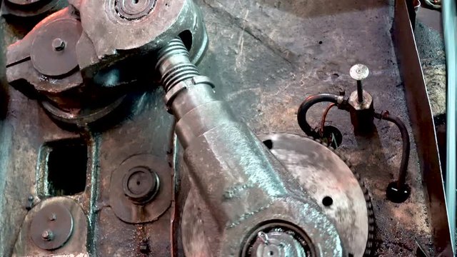 Moving gears of a vintage machine driven by steam engine.