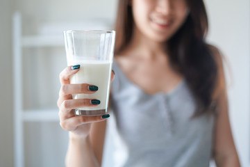 Healthy beautiful woman hold the glass of milk or daily product and drink every day in the morning as breakfast for good healthy with high calcium, protein, vitamin and nutrient.