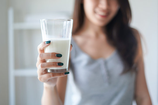Healthy Beautiful Woman Hold The Glass Of Milk Or Daily Product And Drink Every Day In The Morning As Breakfast For Good Healthy With High Calcium, Protein, Vitamin And Nutrient.