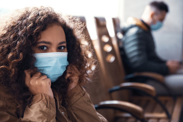 African-American woman with disposable mask indoors. Virus protection - Powered by Adobe