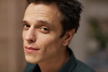 Fototapeta premium Portrait of young handsome man with dark hair looking at camera