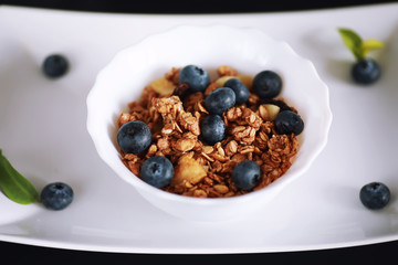 A healthy breakfast cereal with milk and fruit. Oat and corn flakes with chocolate and yogurt. The concept of healthy and vegetarian food.