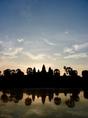 Obraz premium Angkor Wat during sunrise with clouds, shadow Silhouette before lake with reflections, ruins of Angkor, Cambodia