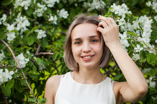 Happy woman in spring park, beautiful young face close up