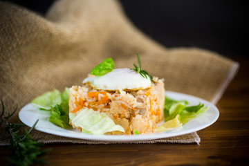 boiled rice with vegetables and fried egg with salad leaves in a plate