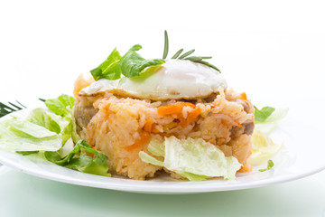 boiled rice with vegetables and fried egg with salad leaves in a plate