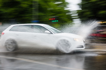 Car splashes water on a rainy day, Sweden.