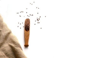 Top view buckwheats on sackcloth with wooden spoons on white background. Buckwheats in a spoon and spread around, gluten free ancient grain for healthy diet. Buckwheat grains. Grain culture.