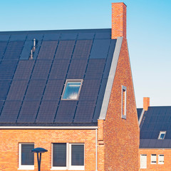 Urban background with modern family Dutch houses in rural neighborhood covered with roof solar...