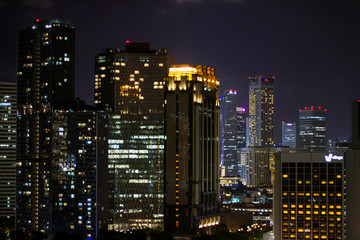Fototapeta na wymiar Night city background, with glowing windows in houses