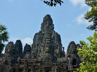 Fototapeta na wymiar Ruins of Angkor, temple of Bayon with face towers, with trees, Angkor Wat, Cambodia