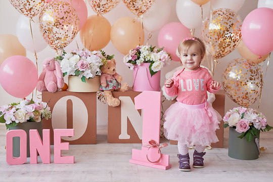Smash cake party. Little cheerful birthday girl with first cake. Happy infant baby celebrating his first birthday. Decoration and photo zone for first year. One year baby celebration. Pink decor.