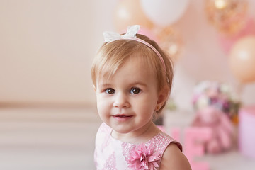 Smash cake party. Little cheerful birthday girl with first cake. Happy infant baby celebrating his first birthday. Decoration and photo zone for first year. One year baby celebration. Pink decor.