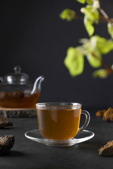 Organic Chaga mushrooms hot beverage in glass cup on black. Close up. Useful coffee alternative to boost immunity during the coronavirus.