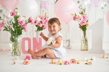 Smash cake party. Little cheerful birthday girl with first cake. Happy infant baby celebrating his first birthday. Decoration and photo zone for first year. One year baby celebration. Pink decor.