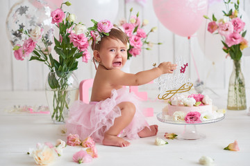 Naklejka na ściany i meble Smash cake party. Little cheerful birthday girl with first cake. Happy infant baby celebrating his first birthday. Decoration and photo zone for first year. One year baby celebration. Pink decor.