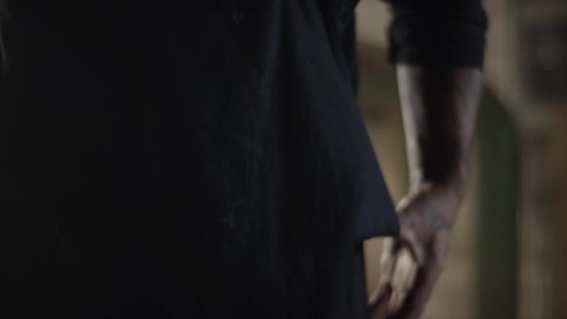 T&auml;ttowierter Mann richtet Sch&uuml;rze